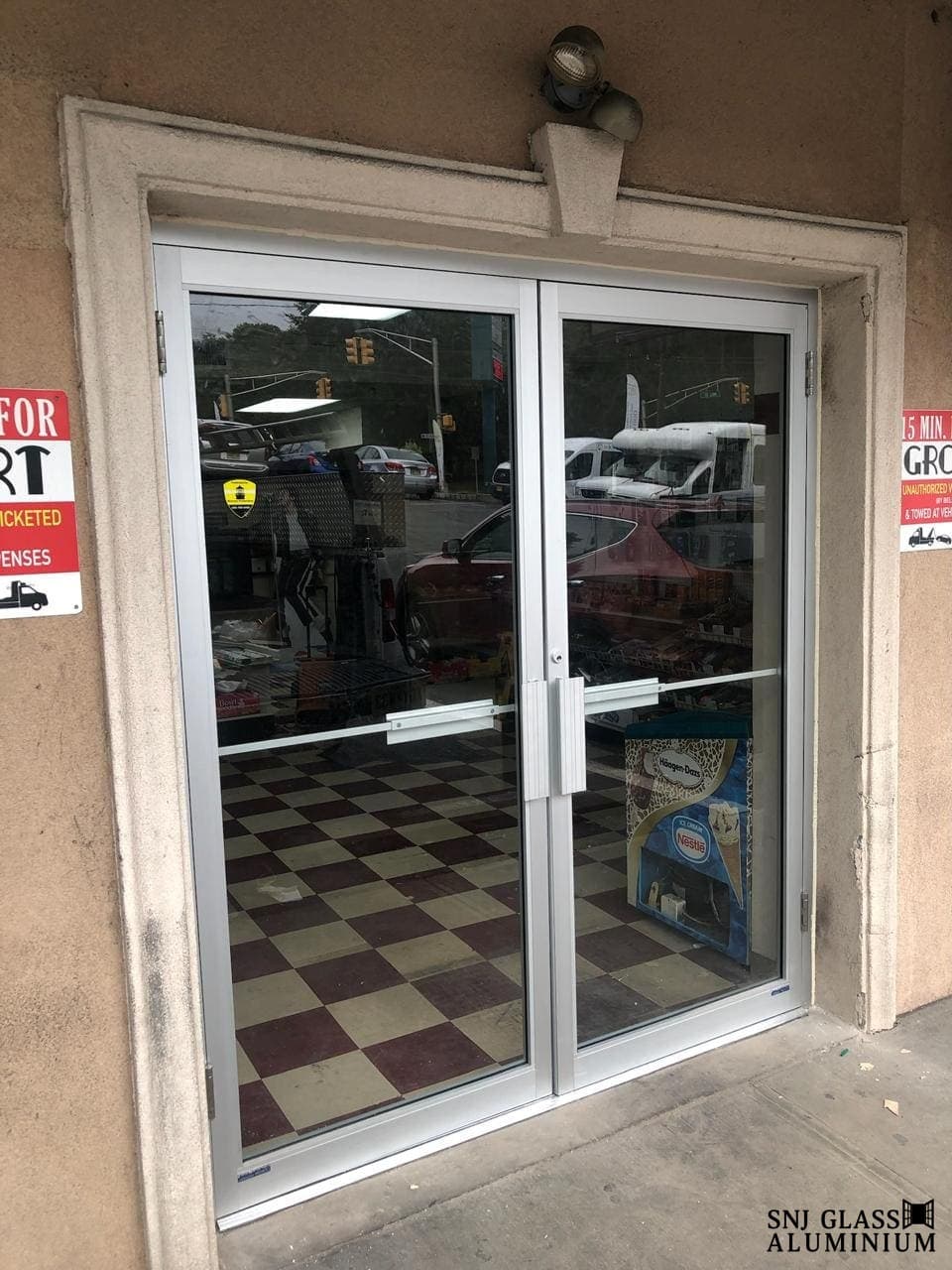 Double glass entrance doors with silver aluminum framing.