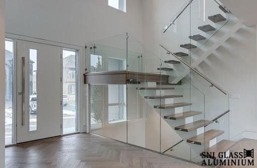 Glass railing enclosing a floating staircase and landing.