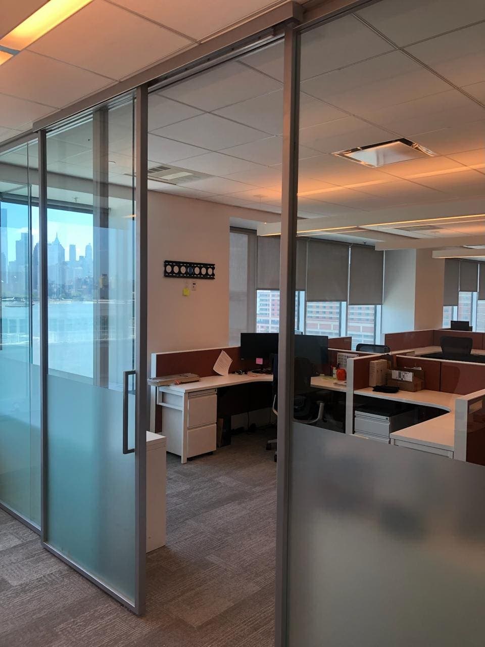 Full-height interior glass partition with a frosted lower panel in an office space.