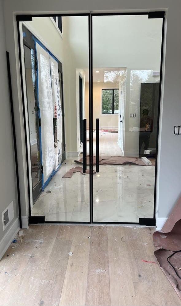 Black-framed glass doorway in a home undergoing renovation.