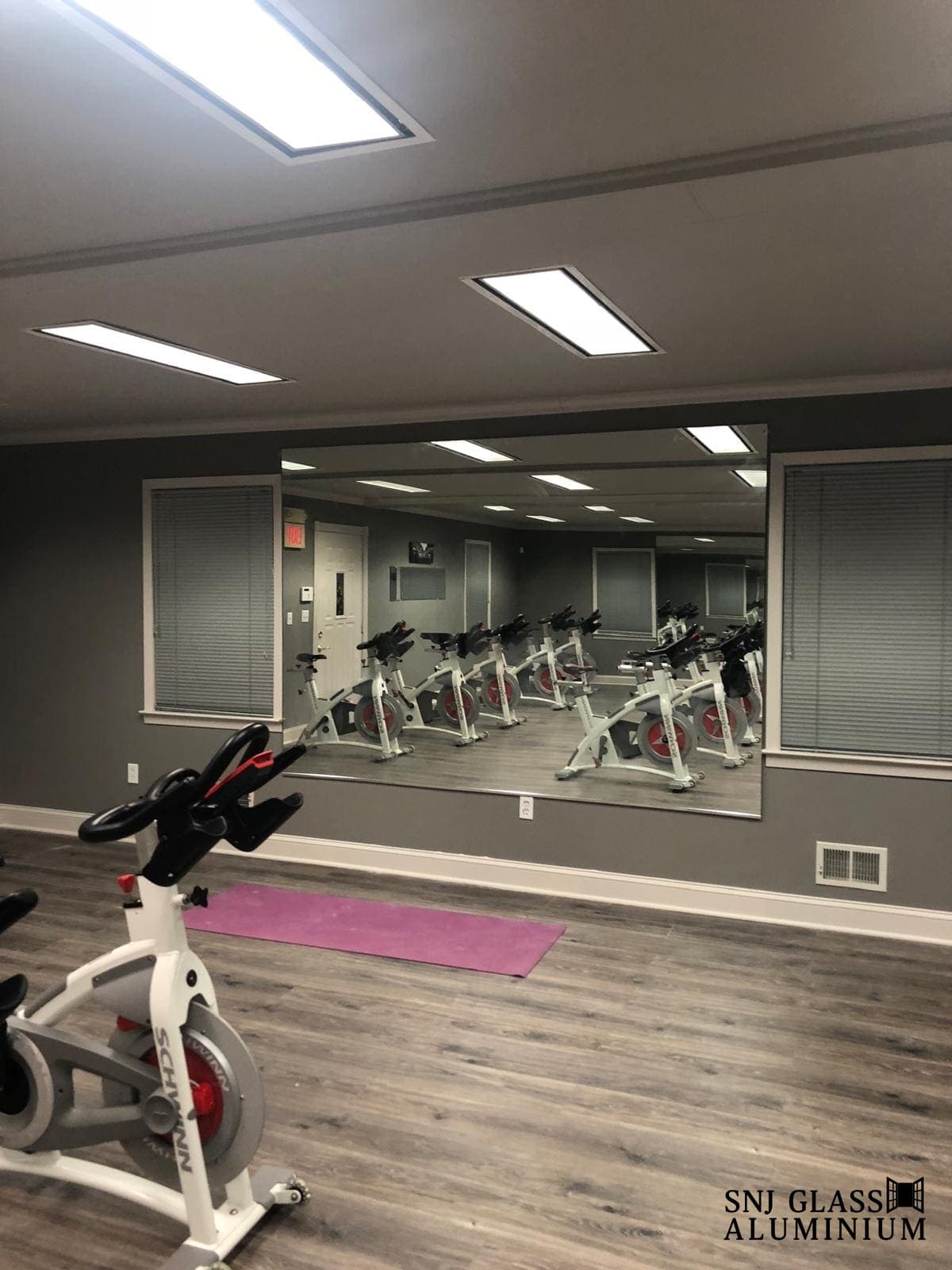 Large wall mirror facing exercise bikes.