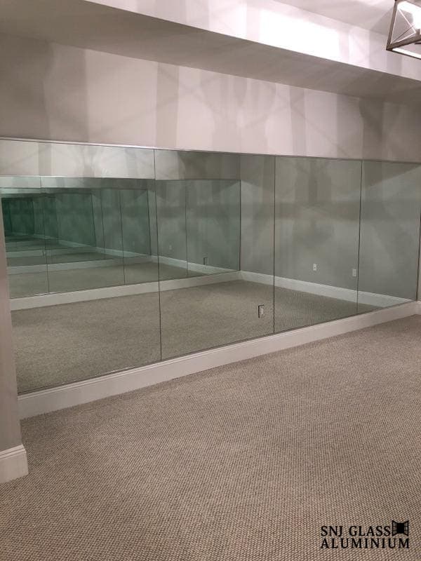 Multi-panel mirrored wall in an empty room.