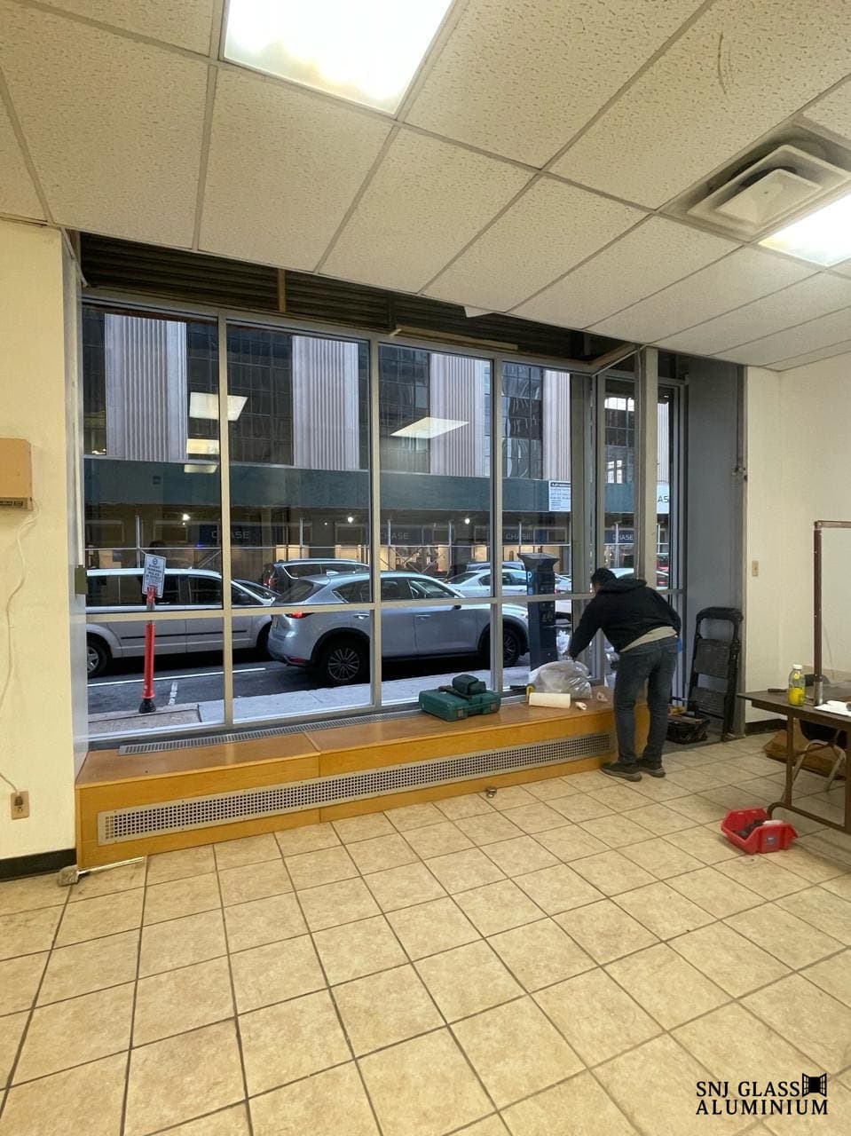Interior view of tall storefront windows during work.