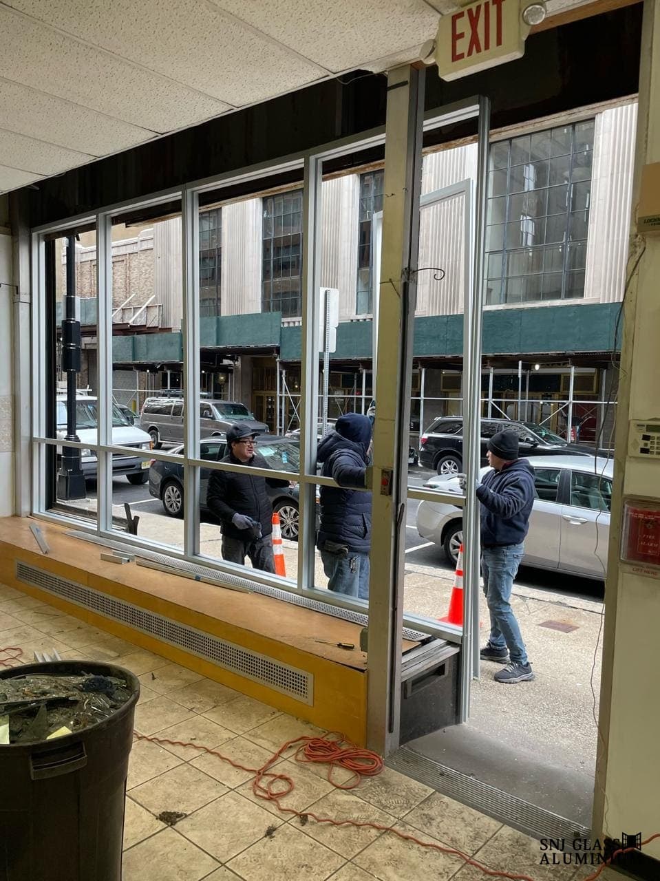 Interior view of storefront framing and an open entry during work.