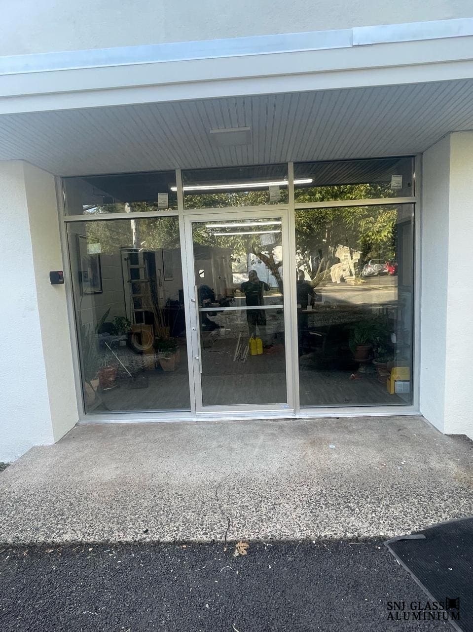 Silver-framed storefront glazing with a central entry.