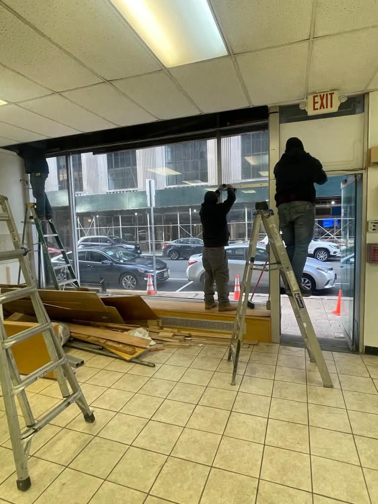 Installers setting the upper storefront glazing at Newark Legal Services.