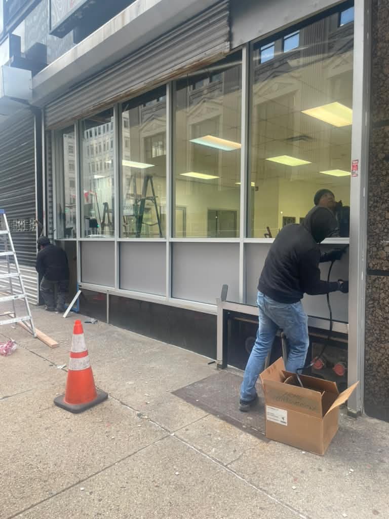 Completed silver-framed storefront windows at Newark Legal Services.