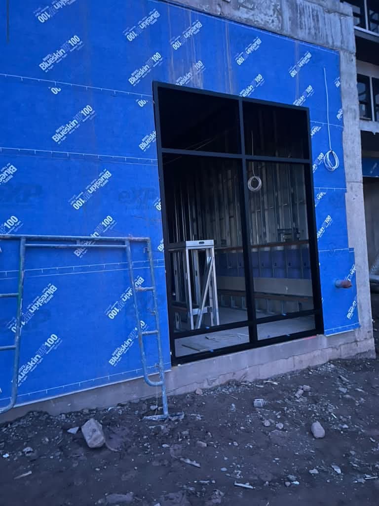 Tall black-framed storefront opening during construction in Cliffside Park.
