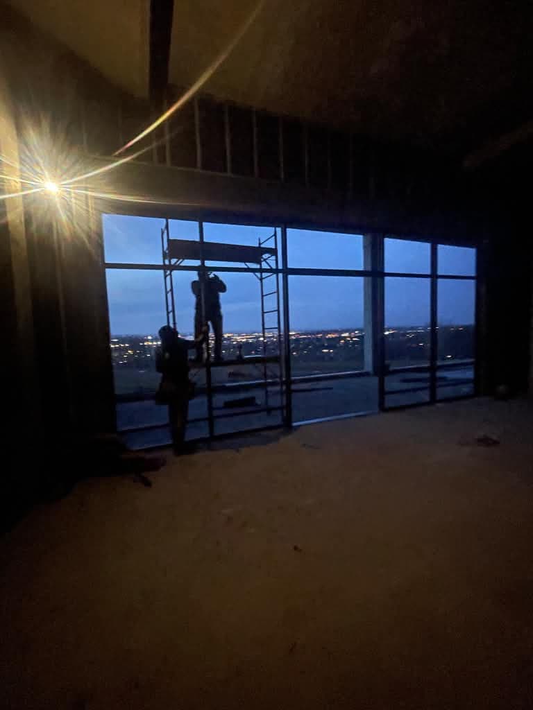 Interior installation of a large black-framed window wall in Cliffside Park.